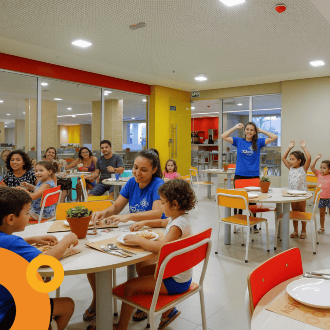 Crianças participando de atividade gastronômica no restaurante infantil do Enjoy Olímpia Park Resort, com monitores e ambiente colorido.