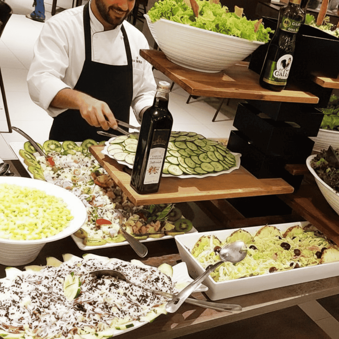Chef preparando buffet de saladas frescas no restaurante do Enjoy Olímpia Park Resort em Olímpia.
