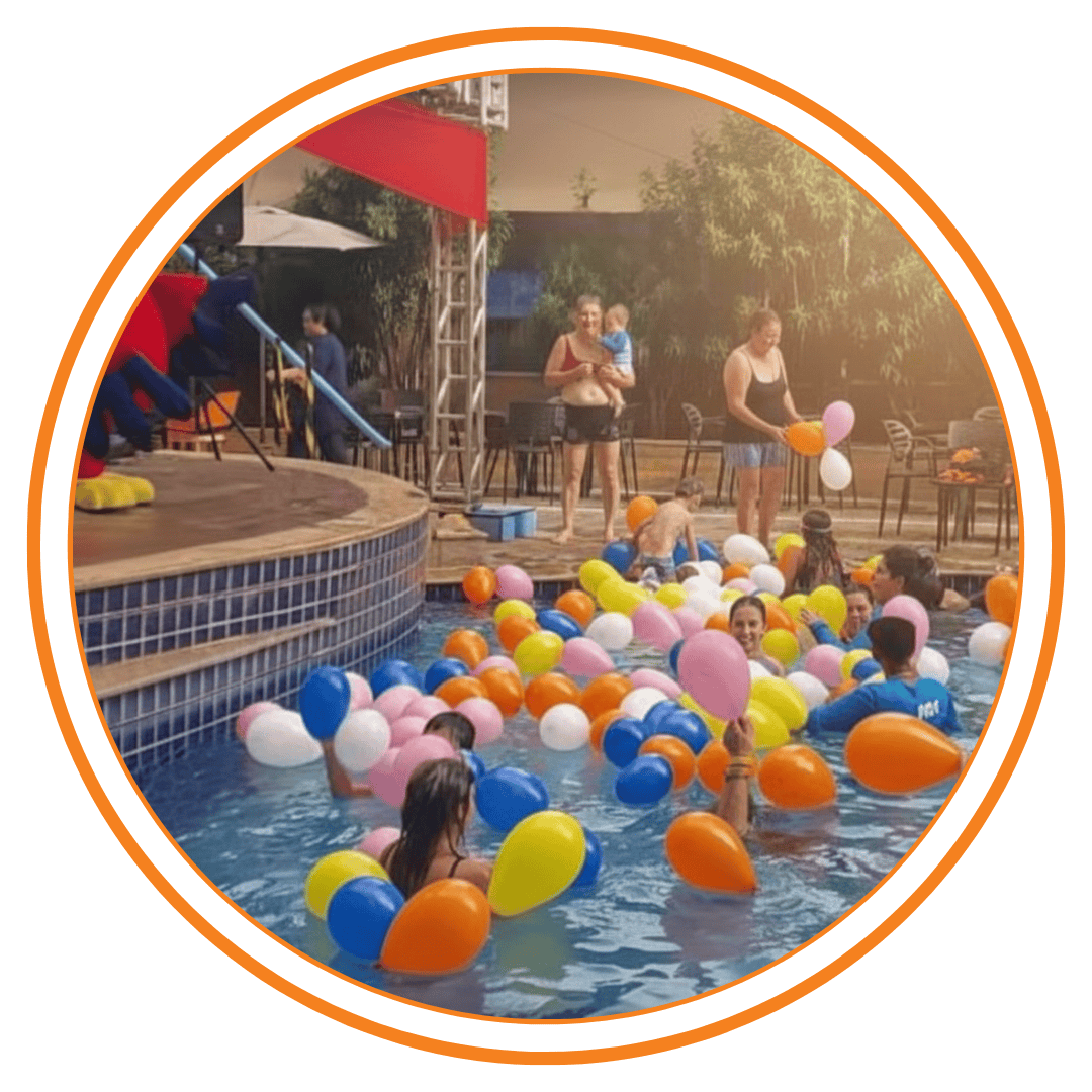 Atividades de recreação infantil na piscina do Enjoy Olímpia Park Resort com monitores e balões coloridos.