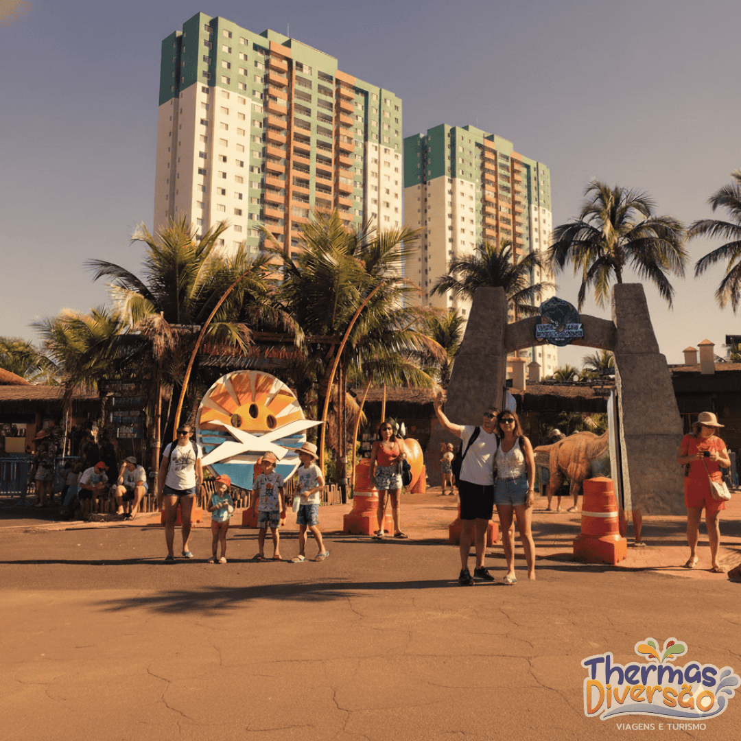 Movimento de visitantes na entrada do parque em Olímpia, cenário que simboliza o turismo que gera riqueza na cidade.